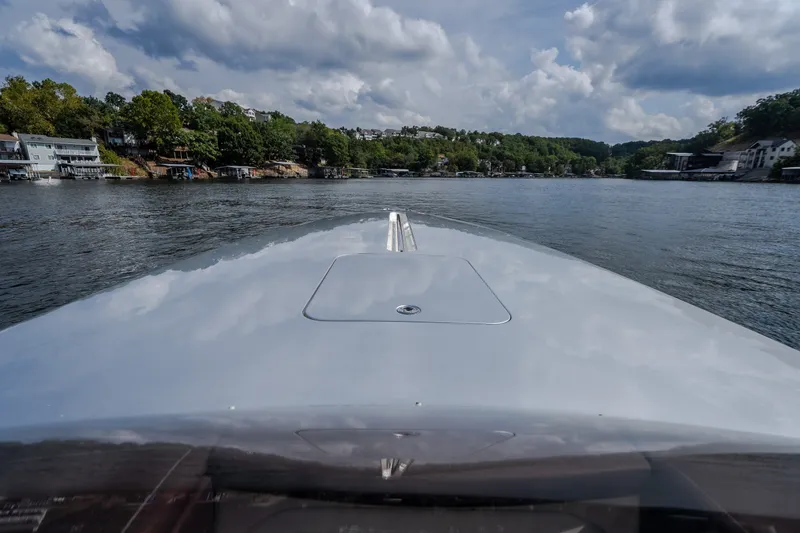 Slide: The Image of 2019 Donzi 41 GT boat cruising on a scenic lake under cloudy skies. - 59