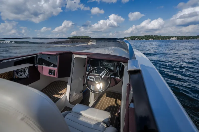 Slide: The Image of 2019 Donzi 41 GT boat interior with steering wheel, dashboard, and scenic water view. - 36