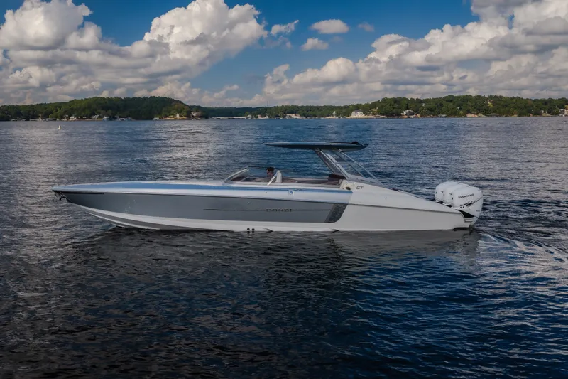 Slide: The Image of 2019 Donzi 41 GT boat on a serene lake under a partly cloudy sky. - 3