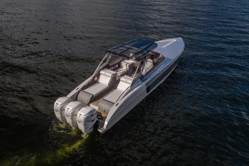 Slide: The Image of 2019 Donzi 41 GT boat cruising on open water, featuring triple outboard engines. - 10