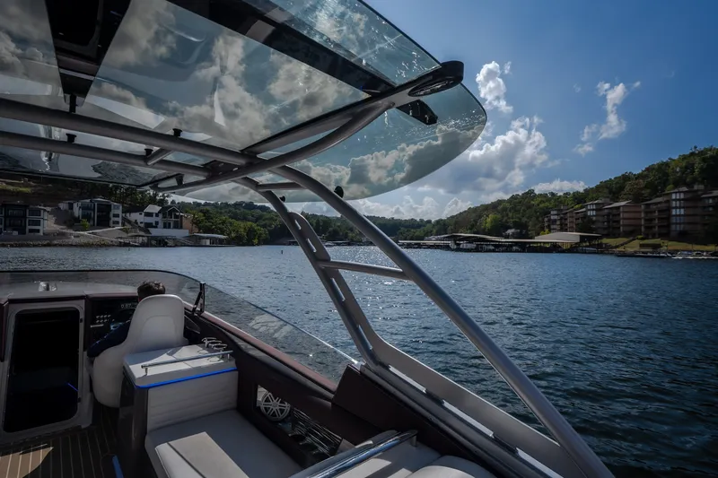Slide: The Image of 2019 Donzi 41 GT boat cruising on a scenic lake under a clear blue sky. - 34