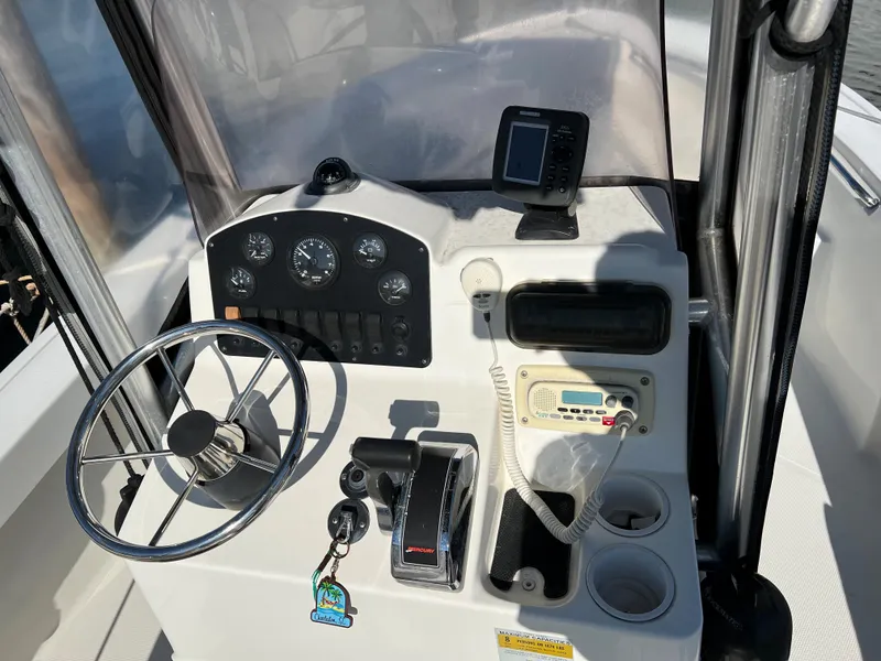 Slide: The Image of Control console of a 2008 Mako 204 CC boat with steering wheel and navigation instruments. - 2