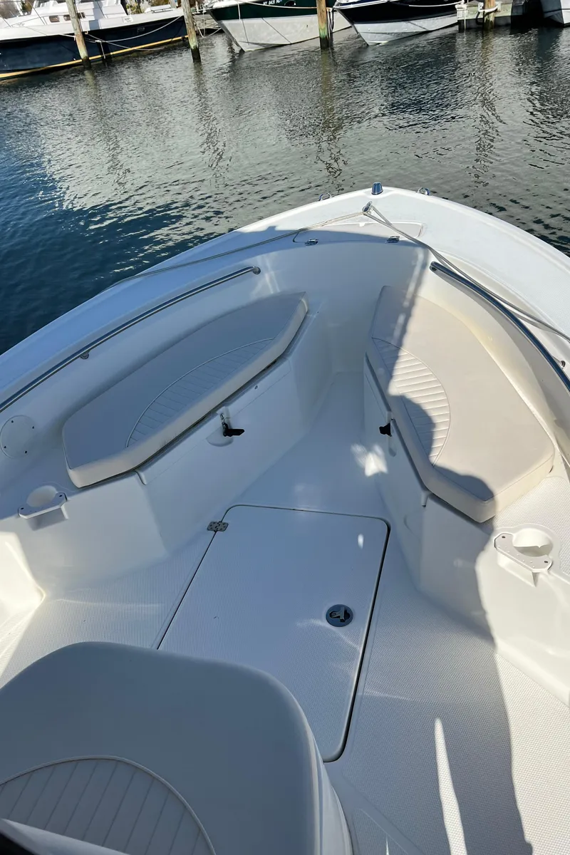 Slide: The Image of 2008 Mako 204 CC boat with seating area at the bow, docked in a marina. - 6