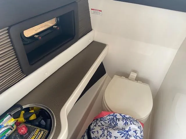 Slide: The Image of 2017 Sea Ray 250 SLX boat interior with toilet and storage compartment. - 16