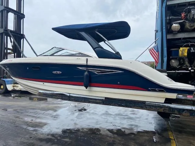 Slide: The Image of 2017 Sea Ray 250 SLX boat on a lift, blue hull with red stripe. - 6