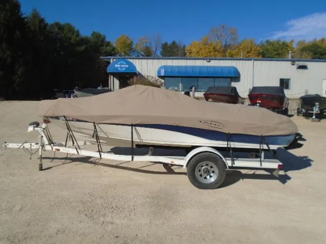 Slide: The Image of 1998 Tahoe Q5L I/O boat on trailer with cover in front of a dealership. - 20