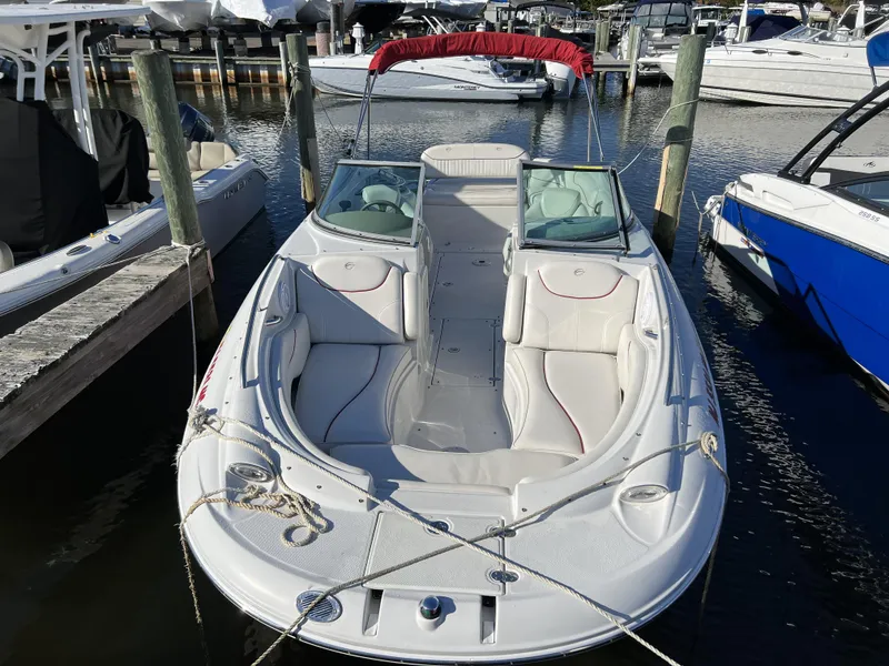 Slide: The Image of 2008 Crownline 240 EX boat docked at marina, white with red accents. - 11