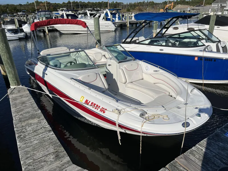 Slide: The Image of 2008 Crownline 240 EX boat docked at a marina with red and white exterior. - 3