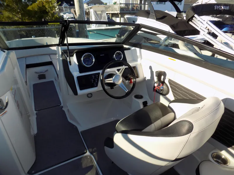 Slide: The Image of 2021 Sea Ray SPX 230 boat interior with steering wheel and seating. - 10