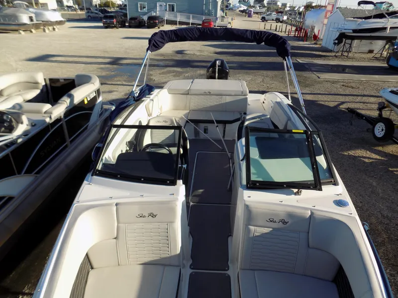 Slide: The Image of 2021 Sea Ray SPX 230 boat with open deck and seating, parked on a trailer. - 9