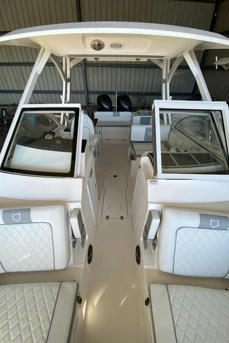Slide: The Image of 2024 Sea Fox 268 Traveler boat interior with white seating and dual consoles. - 10