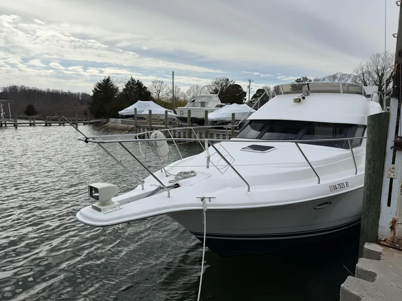 Slide: The Image of 2000 Silverton 35 Convertible yacht docked at a marina on a cloudy day. - 2
