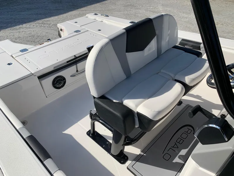 Slide: The Image of 2024 Robalo 266 Cayman boat interior with cushioned seating and storage compartments. - 13