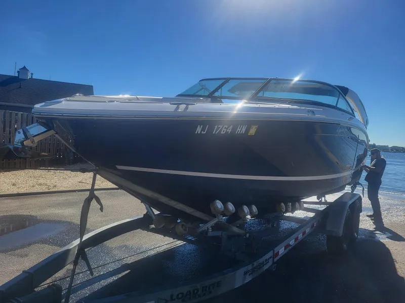 Slide: The Image of 2019 Regal LS6 boat on trailer by waterfront under clear blue sky. - 1