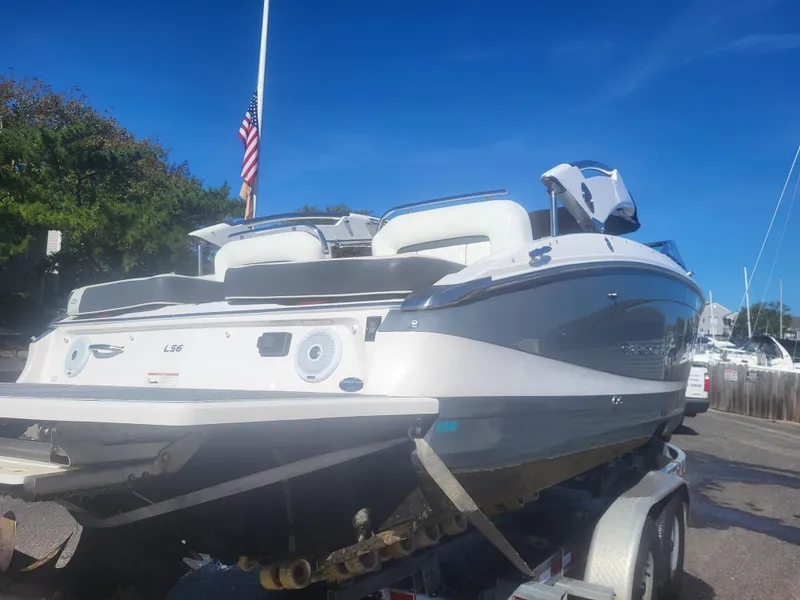 Slide: The Image of 2019 Regal LS6 boat on trailer, parked near marina under clear blue sky. - 3