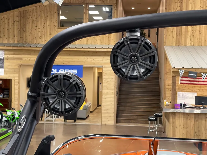 Slide: The Image of 2023 Sanger 237 SX boat with mounted speakers in showroom. - 15