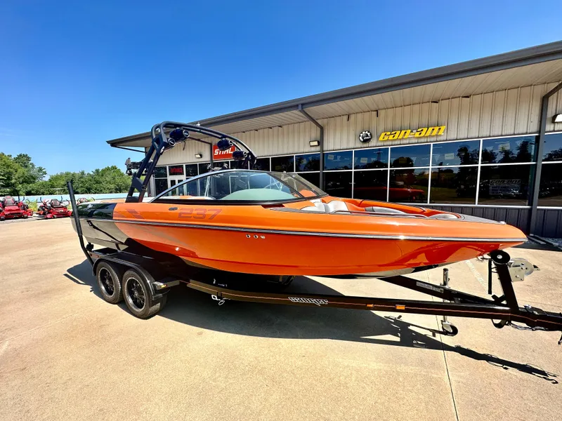 Slide: The Image of 2023 Sanger 237 SX orange boat on trailer outside dealership. - 3