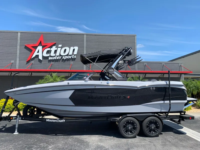 Slide: The Image of 2022 MasterCraft XStar S boat on trailer at Action Water Sports dealership. - 1