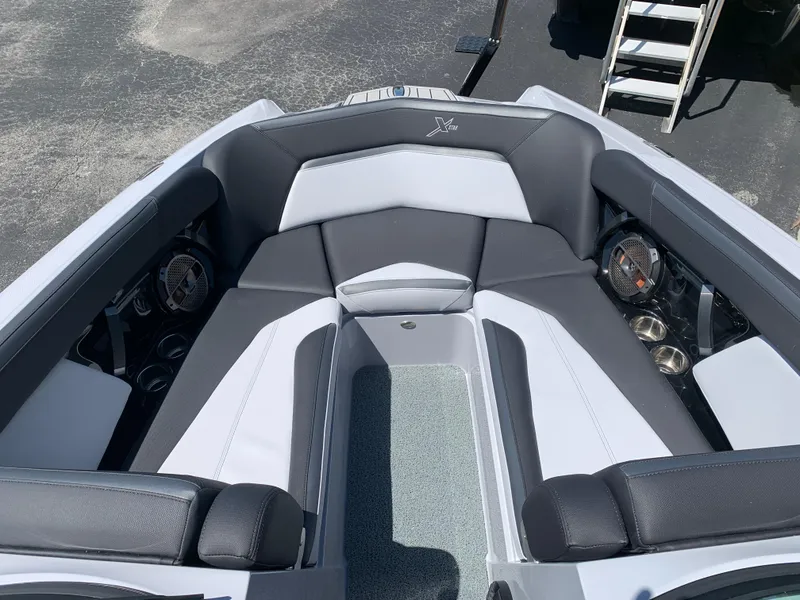 Slide: The Image of 2022 MasterCraft XStar S boat interior with black and white seating and built-in speakers. - 10