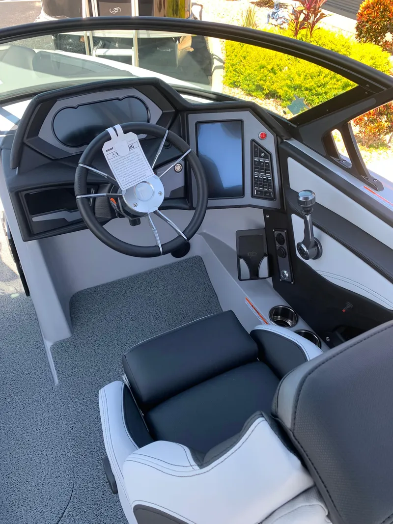 Slide: The Image of 2022 MasterCraft XStar S boat cockpit with steering wheel and control panel. - 12