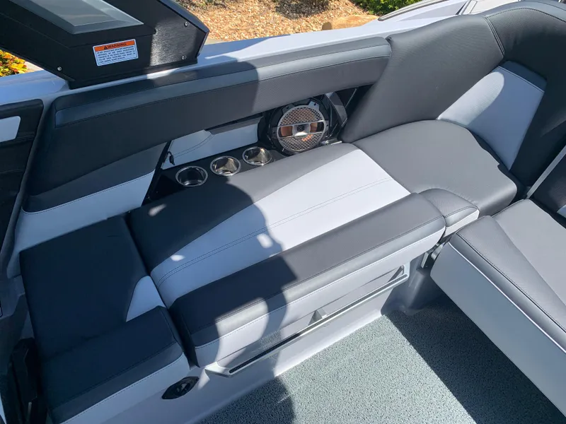 Slide: The Image of 2022 MasterCraft XStar S interior seating with cup holders and speaker. - 13