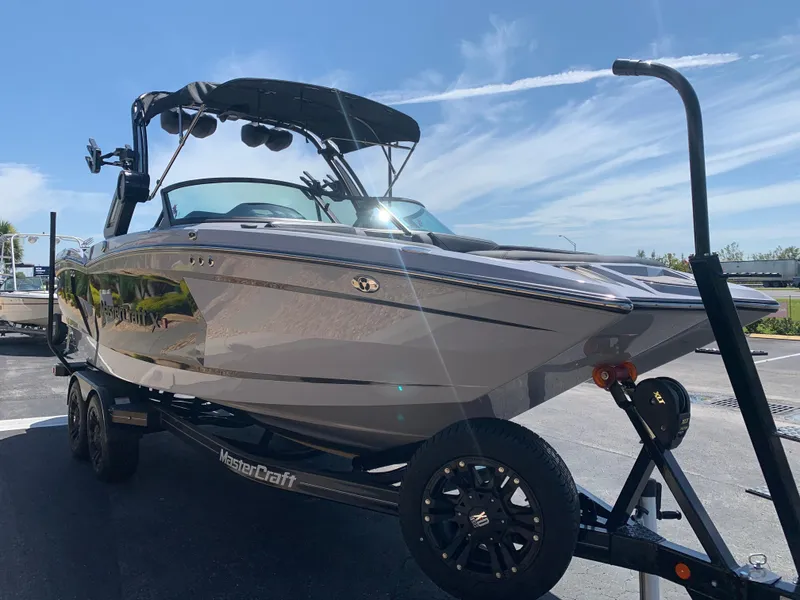 Slide: The Image of 2022 MasterCraft XStar S boat on trailer under clear blue sky. - 3