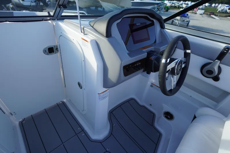 Slide: The Image of 2024 Chaparral 23 SSi OB boat cockpit with steering wheel and control panel. - 18