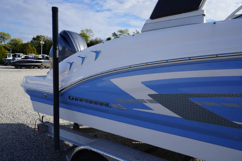 Slide: The Image of 2024 Chaparral 23 SSi OB boat on trailer, showcasing sleek blue and white design. - 2