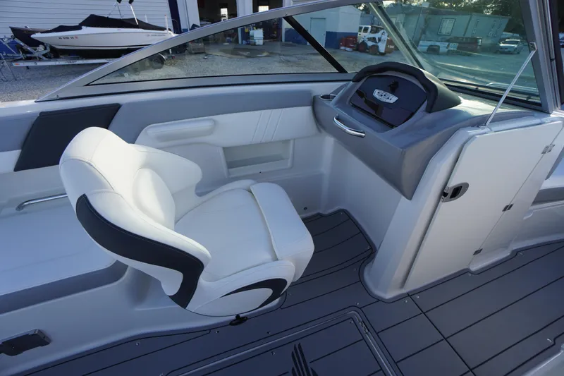 Slide: The Image of 2024 Chaparral 23 SSi OB boat interior with white captain's chair and sleek dashboard. - 20