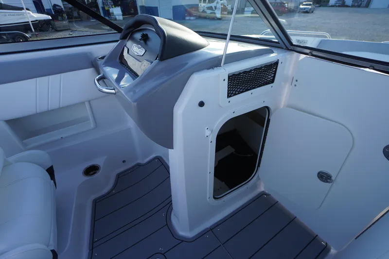 Slide: The Image of 2024 Chaparral 23 SSi OB boat interior with helm and storage compartment. - 22