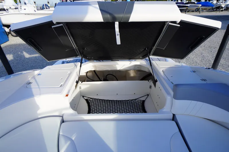 Slide: The Image of 2024 Chaparral 23 SSi OB boat storage compartment with open hatches and netting. - 34