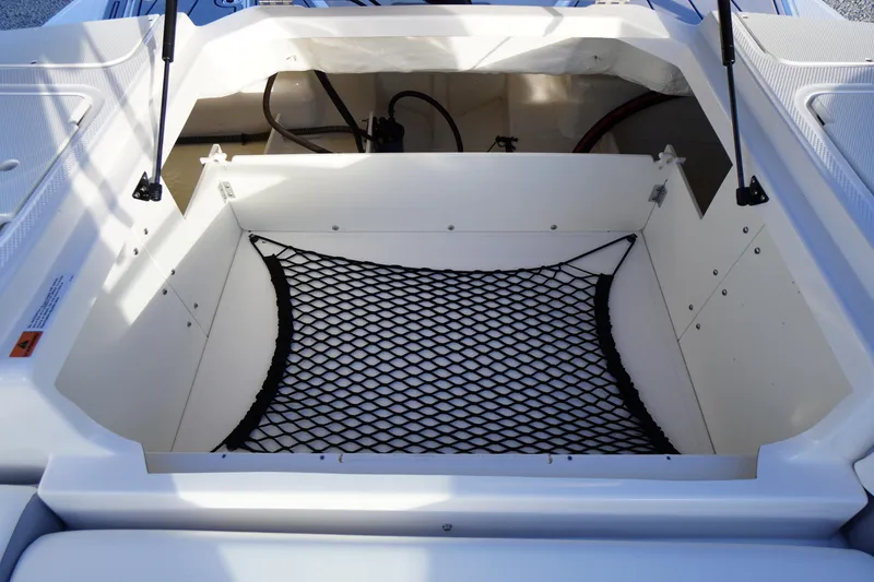Slide: The Image of 2024 Chaparral 23 SSi OB boat storage compartment with netting and hydraulic supports. - 35