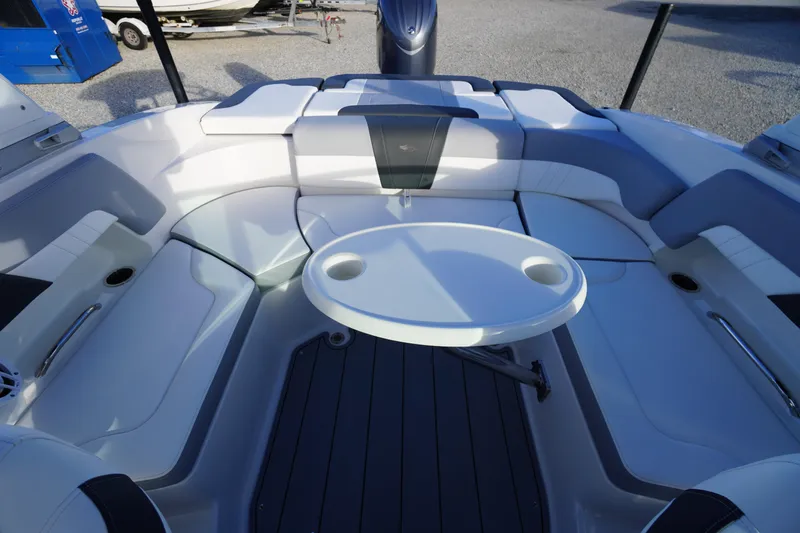 Slide: The Image of 2024 Chaparral 23 SSi OB boat interior with cushioned seating and round table. - 37