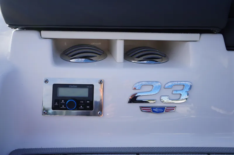 Slide: The Image of 2024 Chaparral 23 SSi OB boat dashboard with Clarion audio system and model emblem. - 4