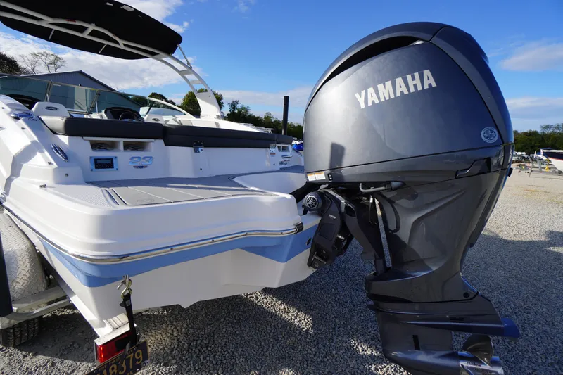 Slide: The Image of 2024 Chaparral 23 SSi OB boat with Yamaha outboard motor, parked on gravel. - 43