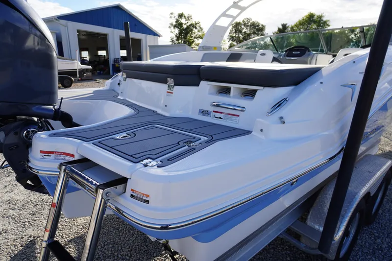 Slide: The Image of 2024 Chaparral 23 SSi OB boat with swim platform and ladder, parked outdoors. - 46