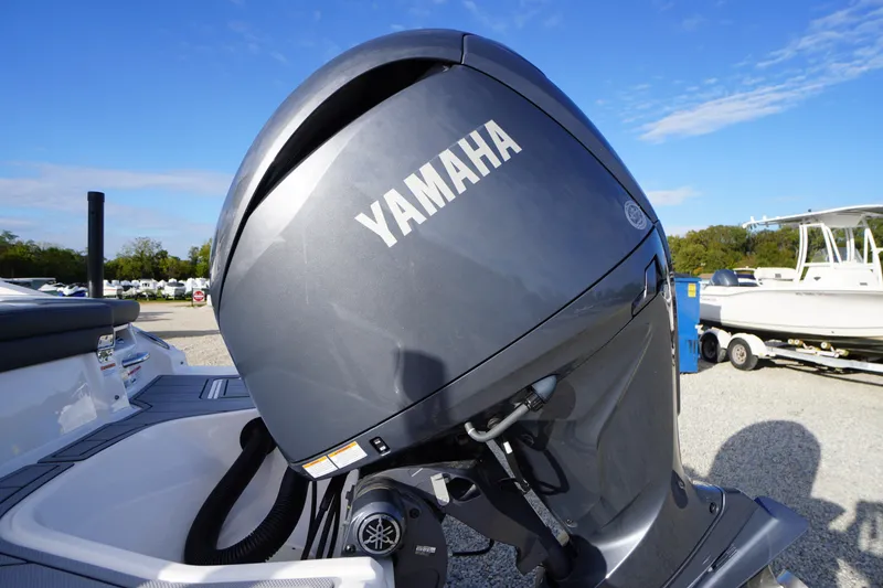 Slide: The Image of 2024 Chaparral 23 SSi OB with Yamaha outboard motor in a boatyard setting. - 48