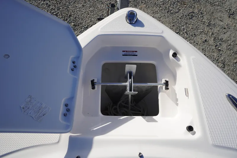 Slide: The Image of 2024 Chaparral 23 SSi OB boat anchor storage compartment, open lid, showing anchor and rope. - 5