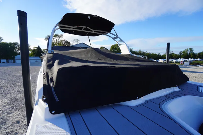 Slide: The Image of 2024 Chaparral 23 SSi OB boat with black cover, parked outdoors. - 51