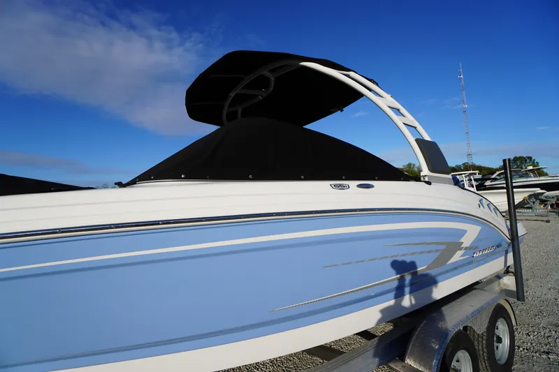 Slide: The Image of 2024 Chaparral 23 SSi OB boat with blue hull and black canopy on trailer. - 52