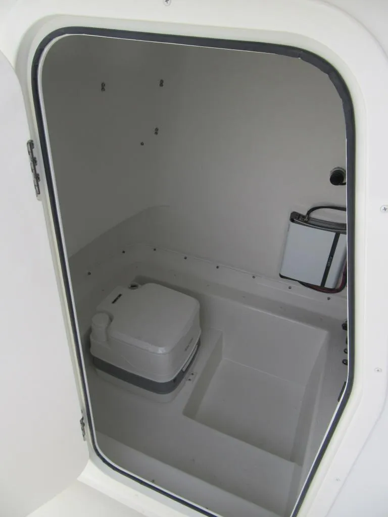 Slide: The Image of 2023 Parker 2501 Center Console boat interior with portable toilet. - 10