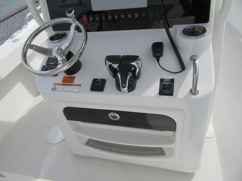 Slide: The Image of 2023 Parker 2501 Center Console boat helm with steering wheel and controls. - 13