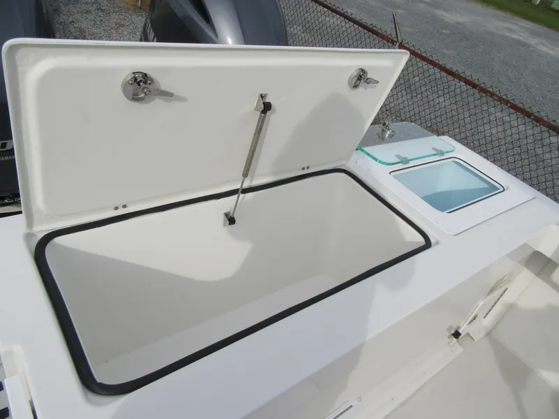 Slide: The Image of 2023 Parker 2501 Center Console boat storage compartment with open lid. - 17