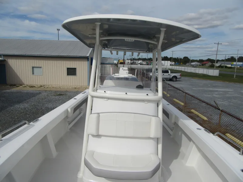 Slide: The Image of 2023 Parker 2501 Center Console boat with T-top and seating, docked at a marina. - 7