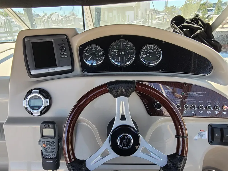 Slide: The Image of Dashboard of a 2010 Sea Ray 240 Sundancer boat with steering wheel and gauges. - 10