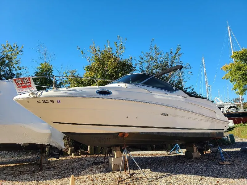 Slide: The Image of 2010 Sea Ray 240 Sundancer boat for sale, displayed on stands, clear blue sky background. - 3
