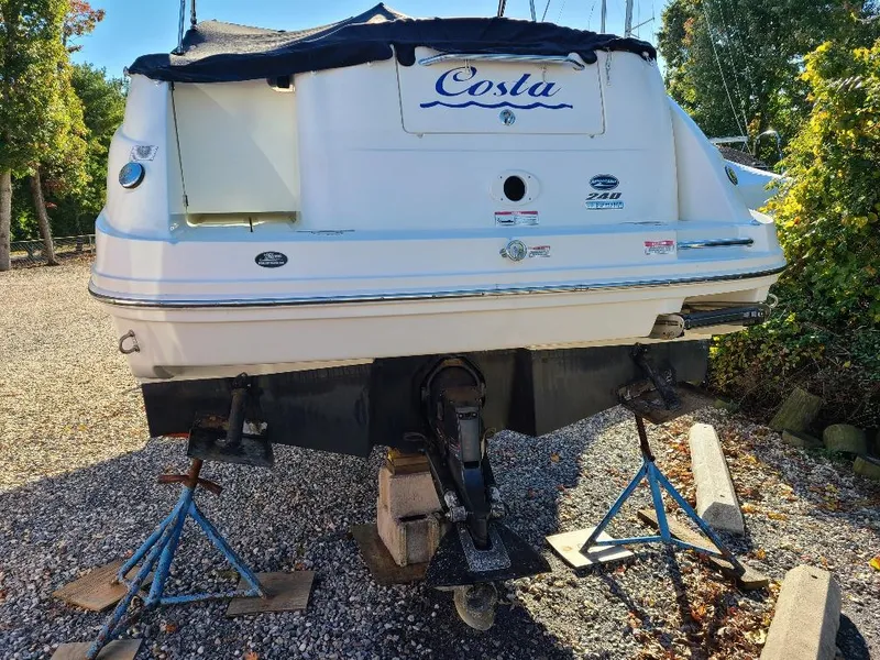 Slide: The Image of 2010 Sea Ray 240 Sundancer boat on stands, rear view, outdoors. - 6