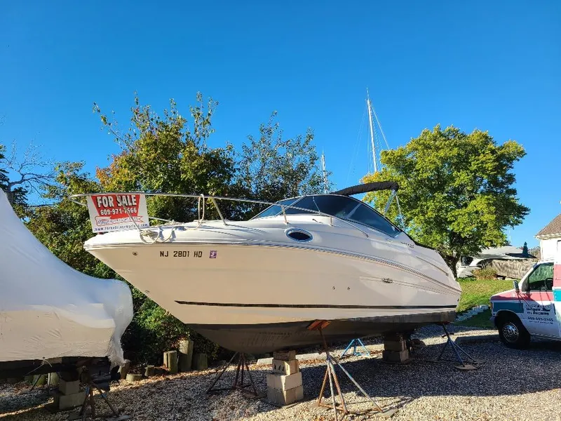 Slide: The Image of 2010 Sea Ray 240 Sundancer boat for sale, displayed on stands, clear blue sky background. - 7