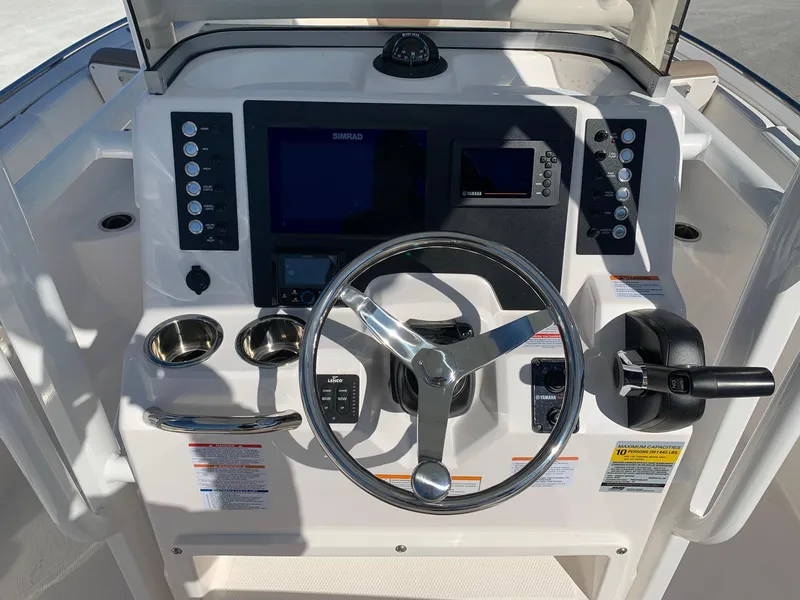 Slide: The Image of 2024 Robalo R222 Center Console boat dashboard with steering wheel and electronic controls. - 11