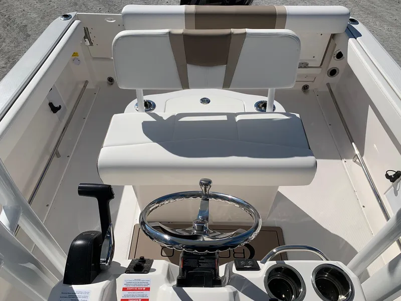Slide: The Image of 2024 Robalo R222 Center Console boat interior with steering wheel and seating. - 13